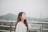 woman closing eyes white standing against stainless steel rail