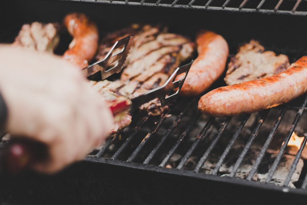 person grilling sausage and meat