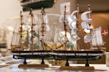 A beautifully crafted wooden model ship displayed in a bright setting.