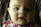 Close-up of a happy baby chewing on a pastel-colored teething ring with soft natural light