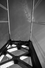 Monochrome image of a large suspension bridge highlighting structural details.