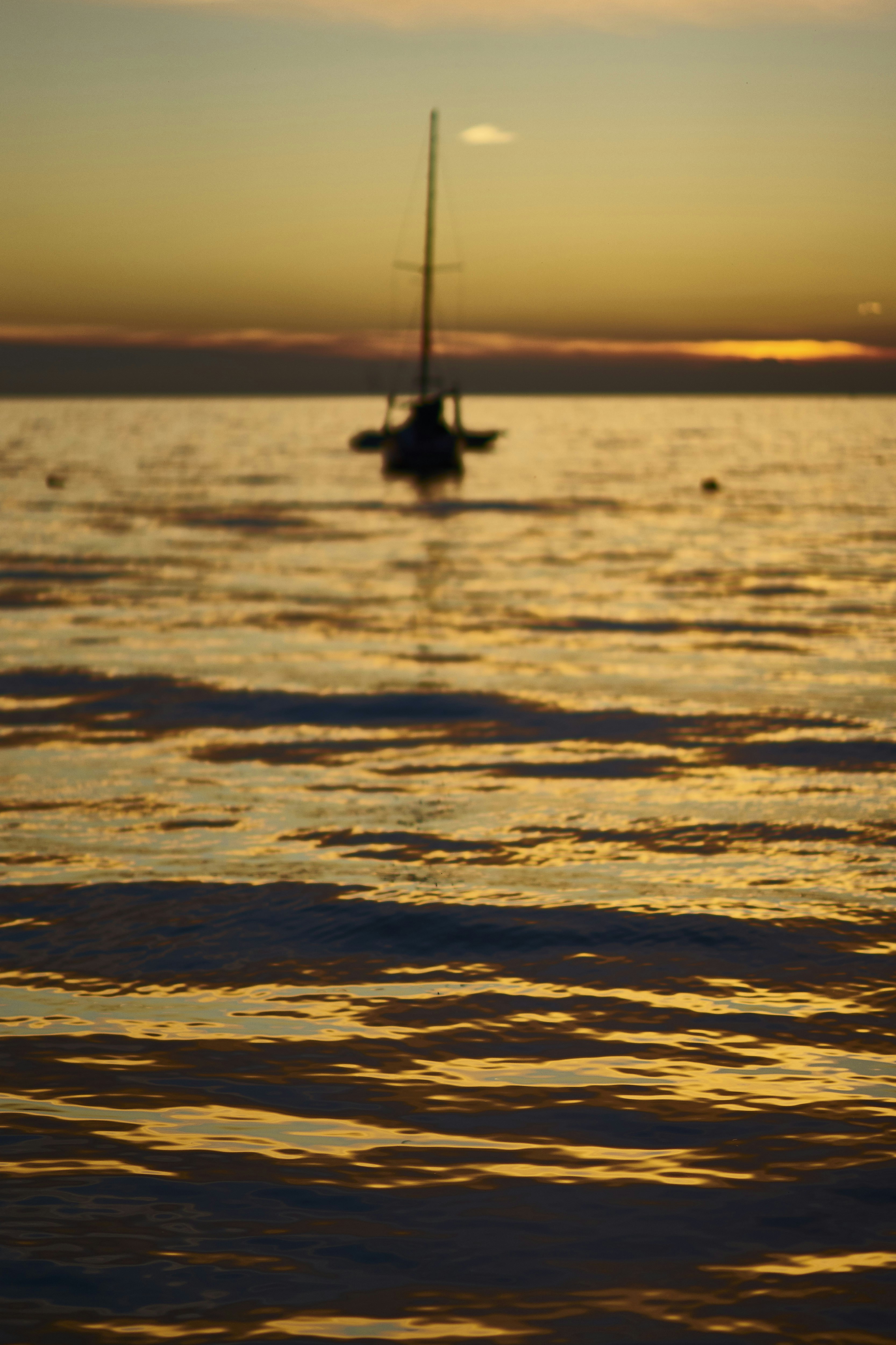 Segelyacht kreuzt auf ruhigem Wasser bei Sonnenuntergang