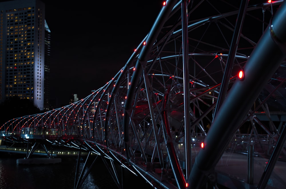 Puente de hélice gris con luces rojas por la noche
