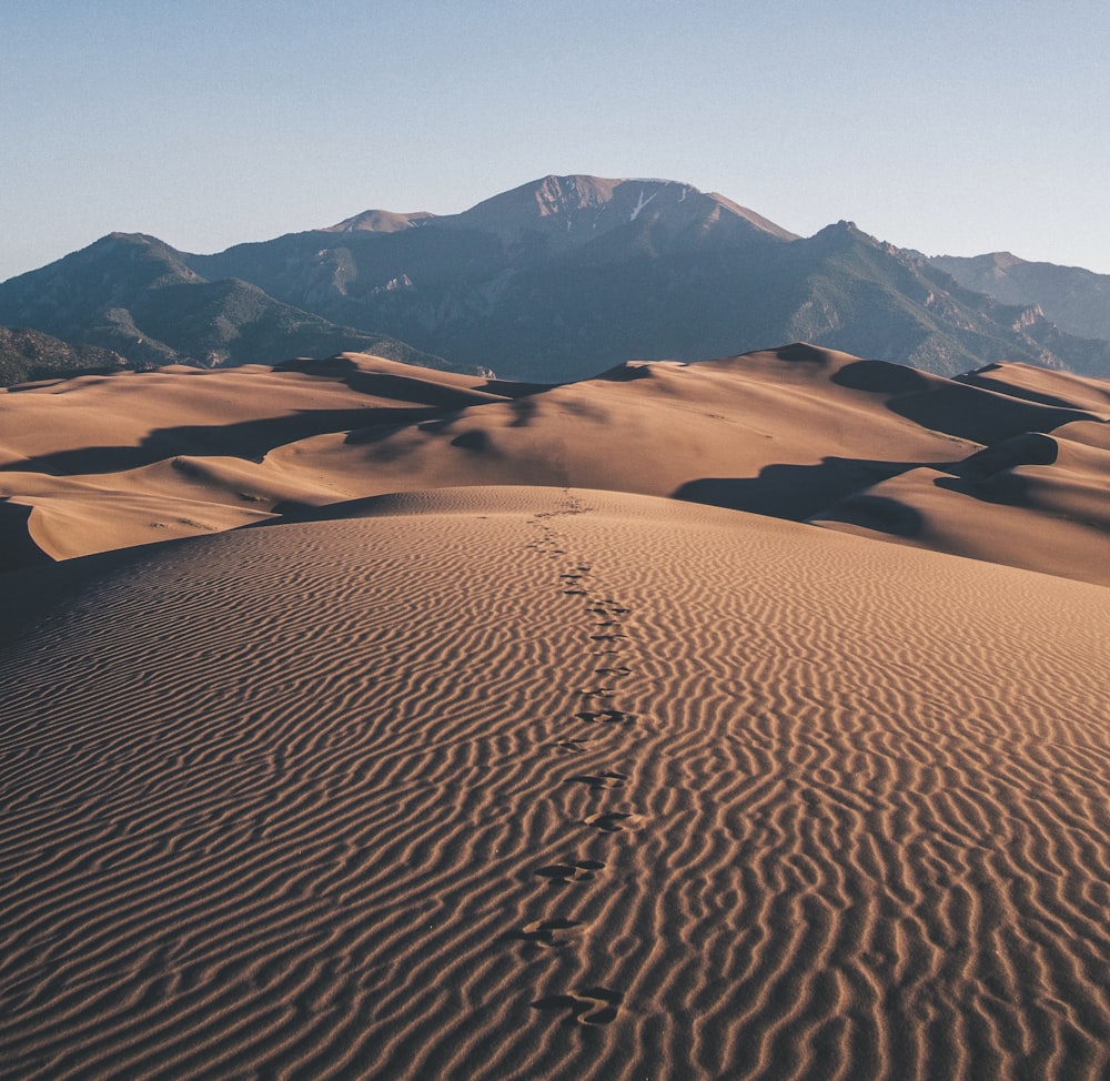 pegadas no deserto em direção à montanha