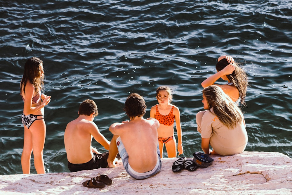 group of kids having a conversation near body of water