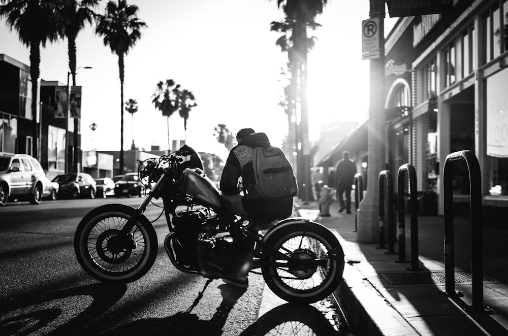 Mann sitzt auf Cruiser-Motorrad auf Graustufen-Fotograuie