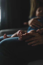 Close-up of a podiatrist gently treating a child's foot in a cozy home setting.