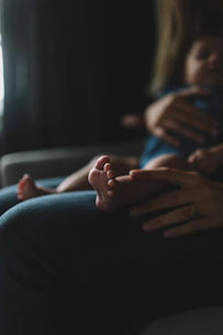 Close-up of a podiatrist gently treating a child's foot in a cozy home setting.
