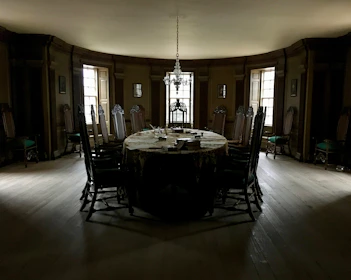 Elegant dining room with dark wood, warm lighting, and stylish table settings.