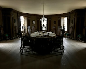 Elegant dining room with dark stone textures and bronze accents, softly lit.