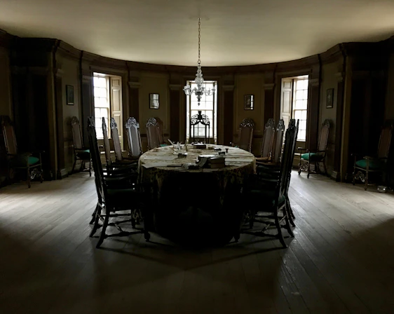 An elegant private dining room bathed in warm golden light, set for an intimate executive dinner.