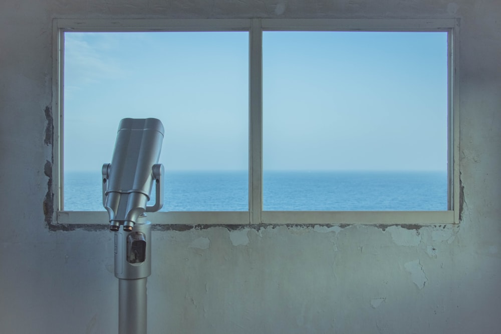 gray metal telescope near closed window