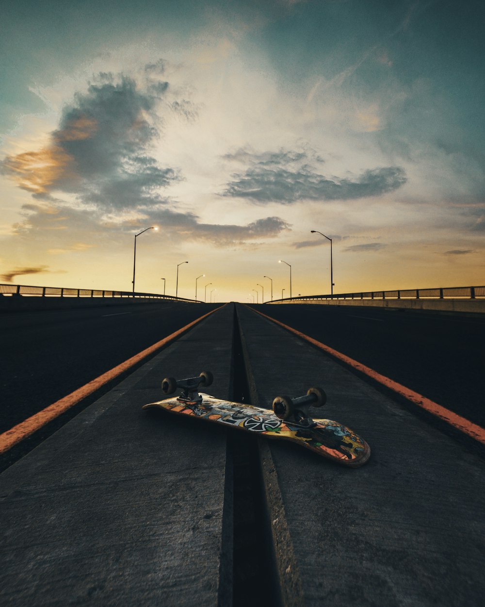 black skateboard on black asphalt road under gray cloudy sky during daytime