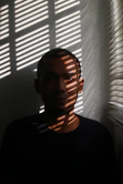 A contemplative portrait of a person seated in a serene, dimly lit listening room.