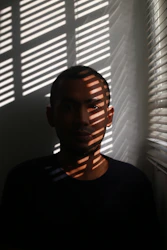 Calm, faceless silhouette of a person sitting peacefully in a softly lit room.
