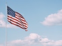 flag of U.S.A. under white clouds during daytime