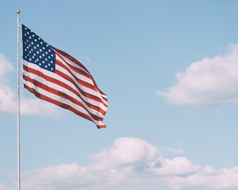 flag of U.S.A. under white clouds during daytime