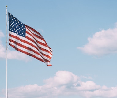 flag of U.S.A. under white clouds during daytime