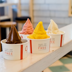 four assorted flavor of ice cream on white wooden table