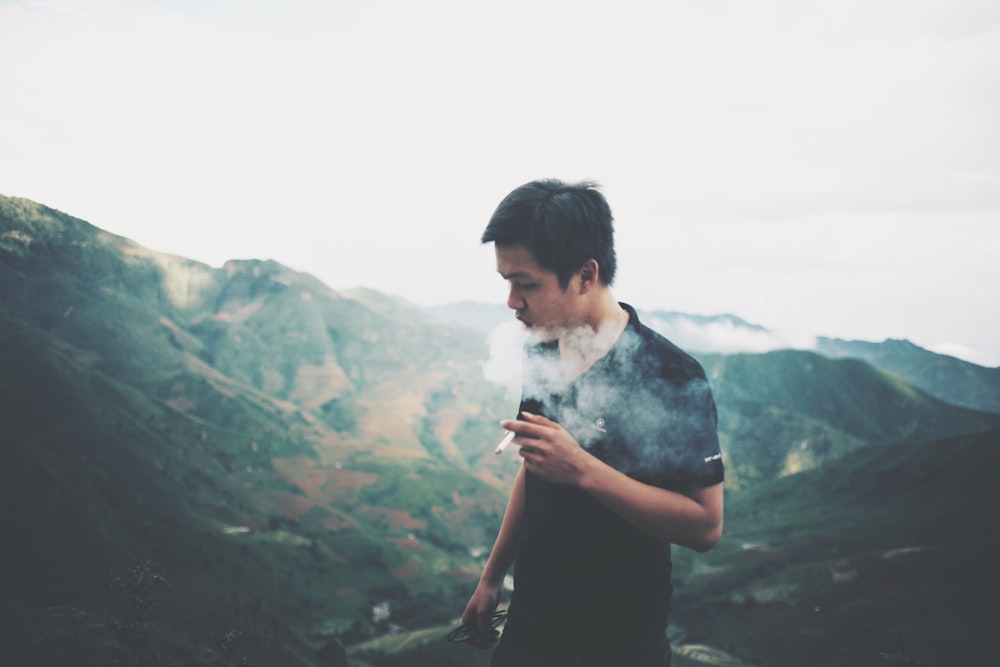 homme fumant sur le sommet de la montagne