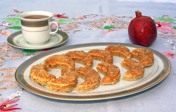 Traditional Armenian patterned cloth draped over a table with freshly baked focaccia and apricot decorations.