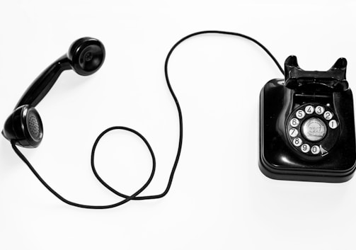 photo of black rotary phone against white background