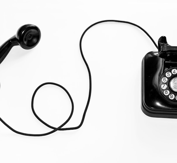 photo of black rotary phone against white background