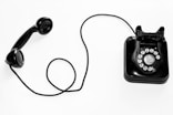 photo of black rotary phone against white background