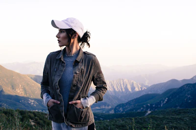 woman in brown jacket standing on top of mountain during daytime