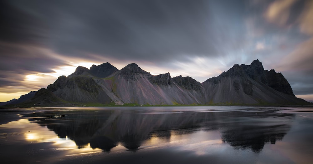 fotografia di paesaggio di montagne vicino allo specchio d'acqua