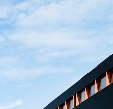 Modern building facade with clear structural details under a blue sky.