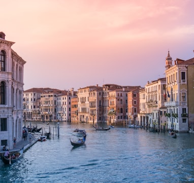 photo of gondolas on body of water between buildings