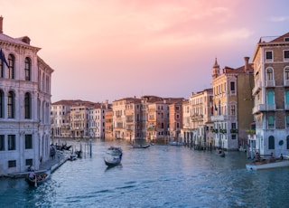 photo of gondolas on body of water between buildings