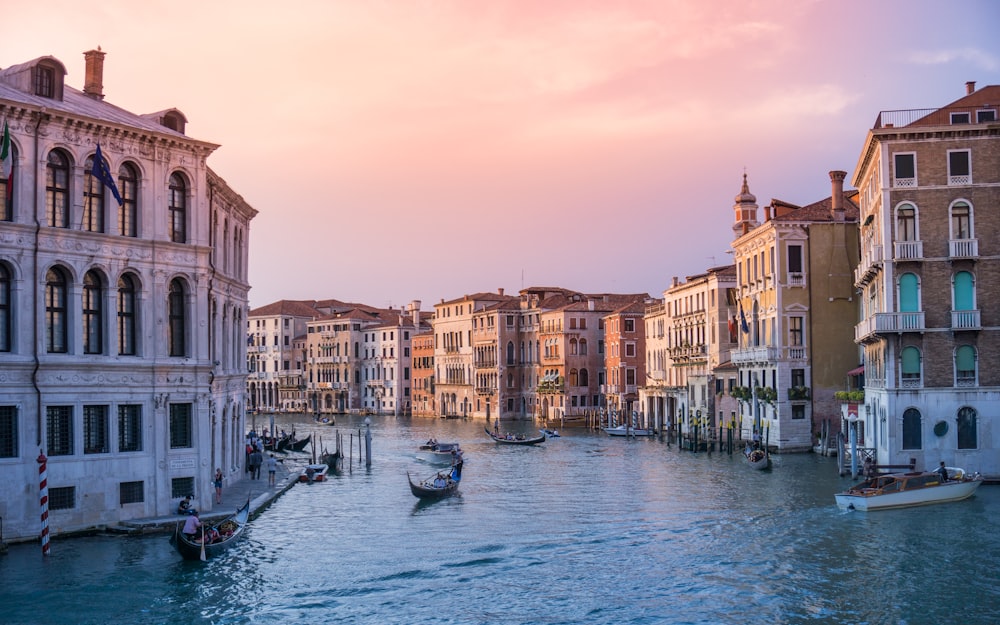 photo of gondolas on body of water between buildings