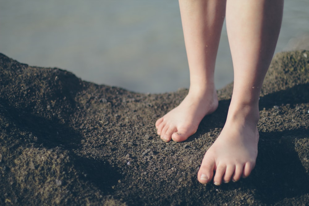 person stepping on grey stone