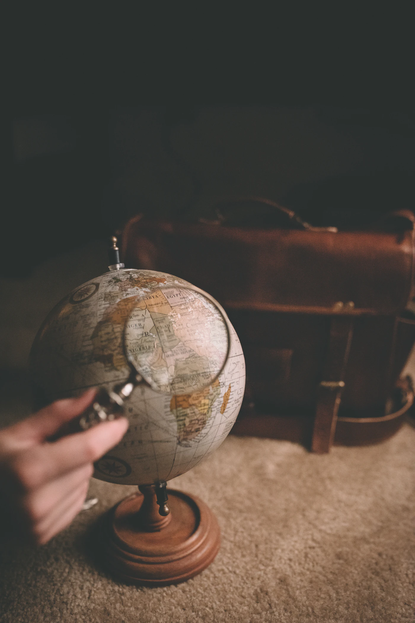 Analyse minutieuse d'un globe terrestre à la loupe, symbolisant l'expertise géopolitique de la CIDEGEC
