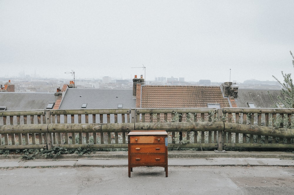 brown wooden dresser near brown fence during daytime