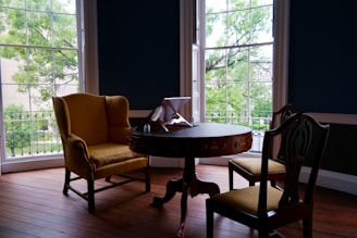 A cozy guest room with soft beige and light green accents, featuring a stylish digital guest map on a tablet.