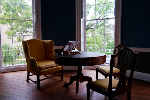 A cozy guest room with soft beige and light green accents, featuring a stylish digital guest map on a tablet.