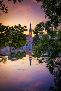 A serene sunset behind musical notes floating over a church steeple.