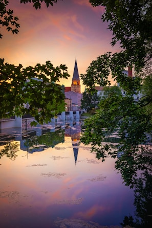 A serene sunset behind a church steeple with soft glowing light.