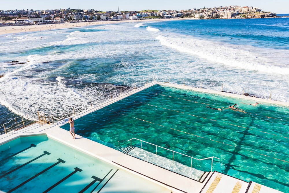 bird's-eye view photography of person standing beside swimming pool