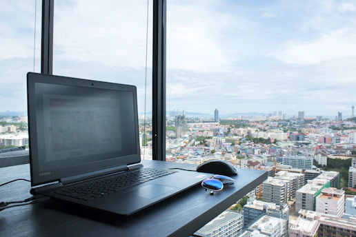 A recruiter reviewing resumes on a laptop with a Panama city skyline visible through the window.