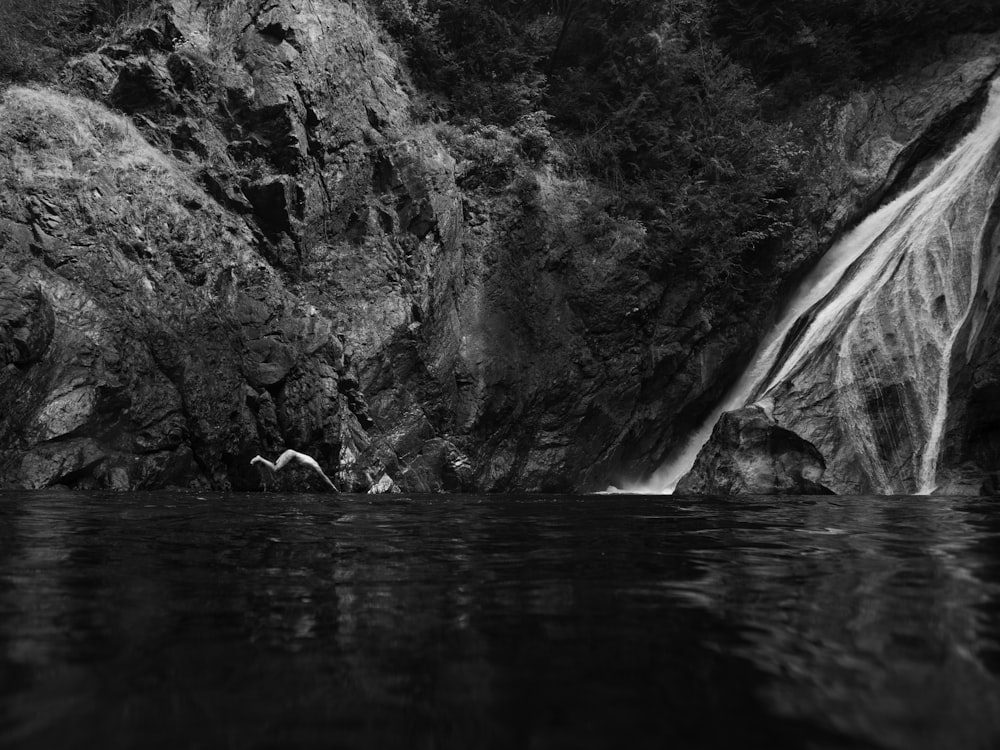 fotografia in scala di grigi della cascata che scorre