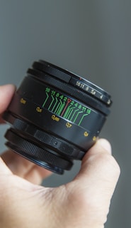 person holding black camera lens