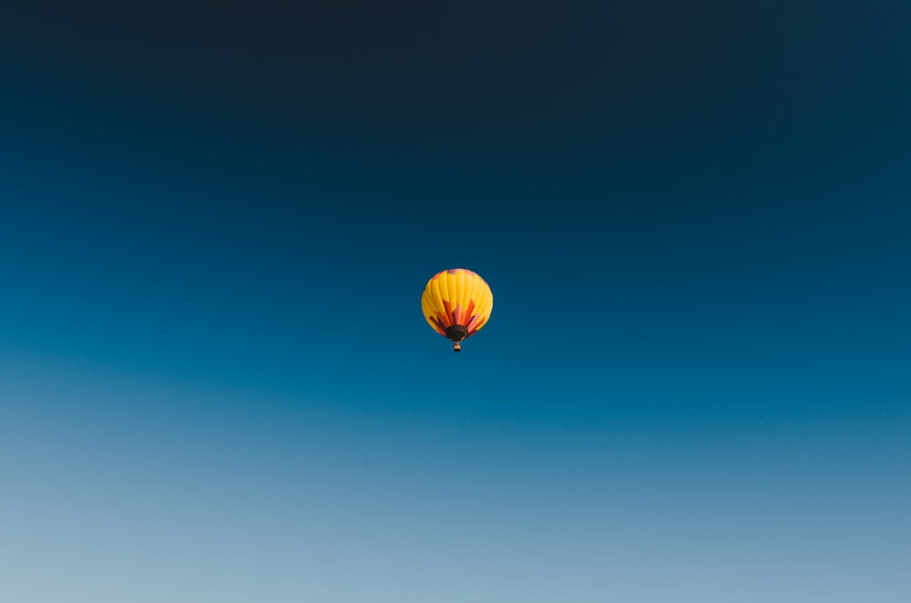 Fotografie aus der Wurmperspektive des gelben Heißluftballons am Himmel