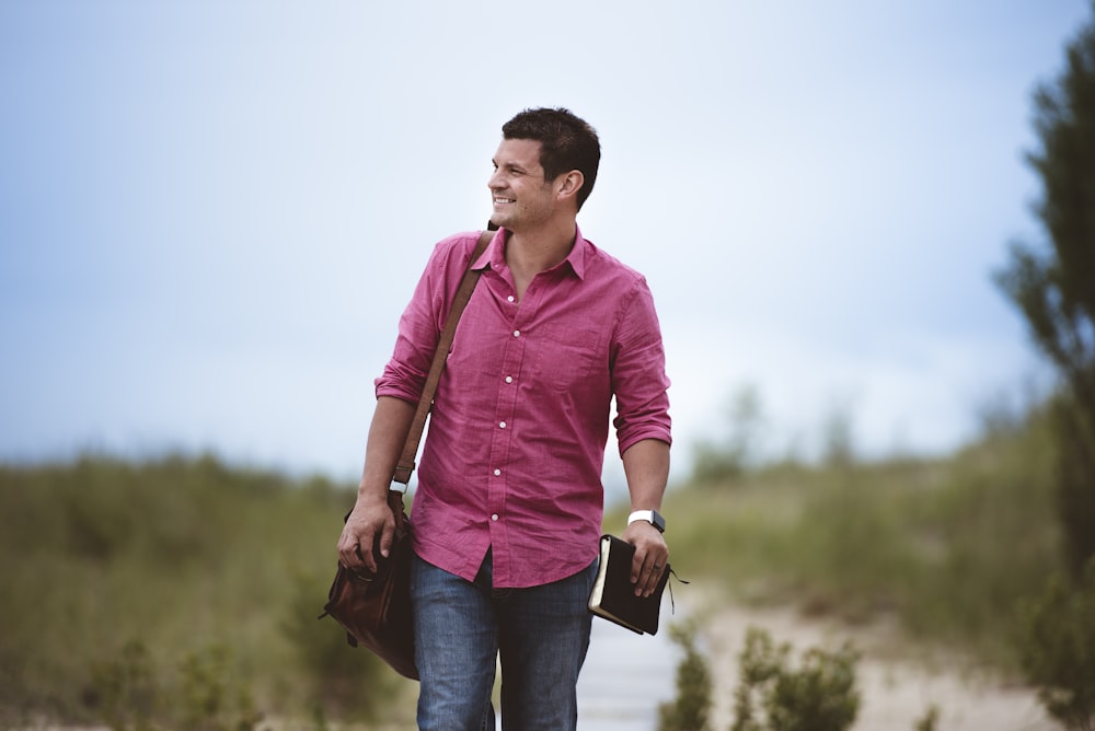 man carrying bag walking on street