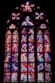 Colorful stained glass window depicting a serene religious scene.