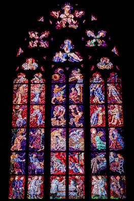 Colorful stained glass window depicting a serene religious scene.