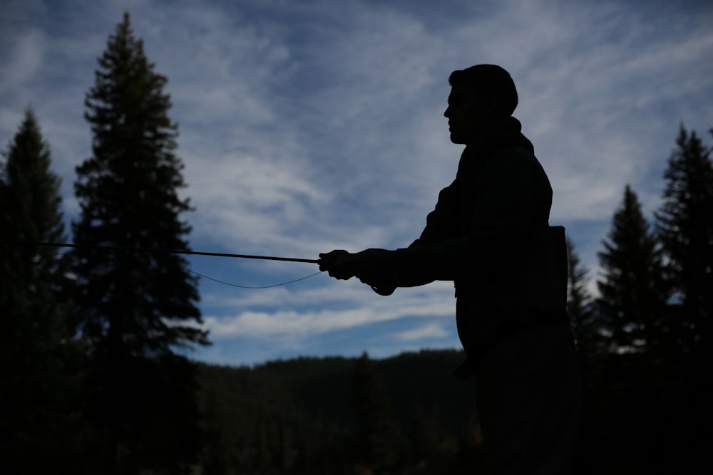 silhouette of person fishing during nighttime